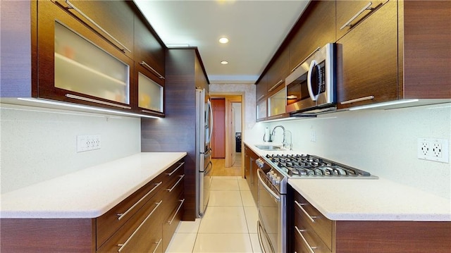 kitchen with light tile patterned flooring, appliances with stainless steel finishes, and sink