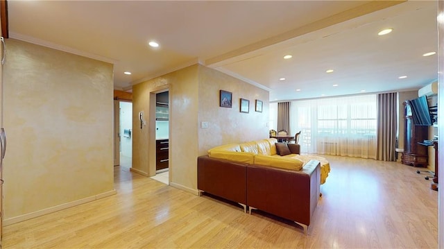 living room featuring light hardwood / wood-style flooring, ornamental molding, and a wall unit AC