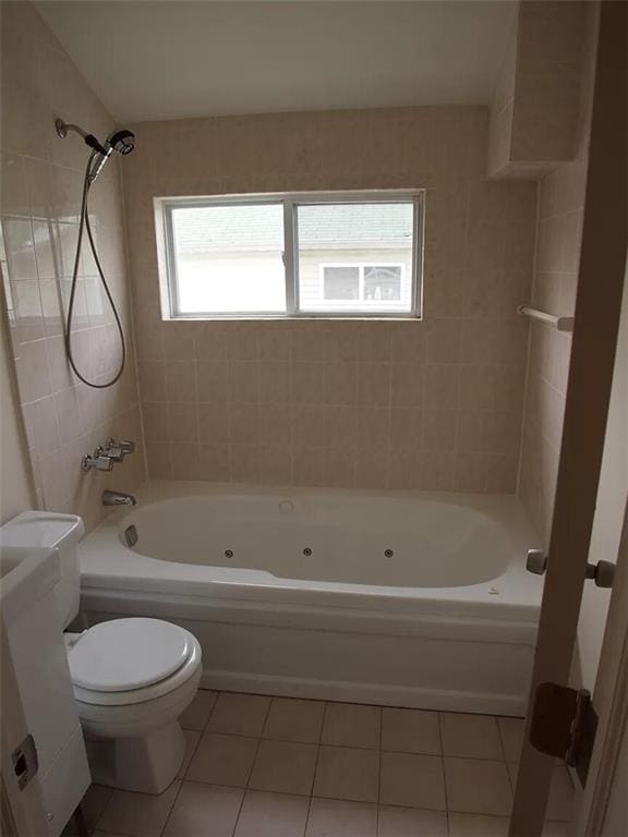 bathroom with tile patterned floors, tiled shower / bath combo, and toilet