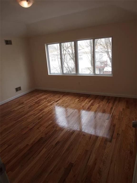 unfurnished room with dark hardwood / wood-style flooring and plenty of natural light