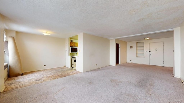 unfurnished living room featuring a textured ceiling and light colored carpet