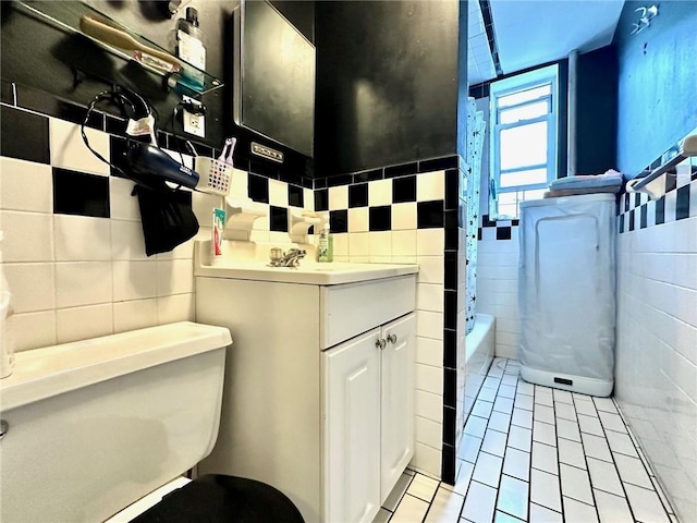 full bathroom featuring vanity, tile patterned floors, a bath, and tile walls