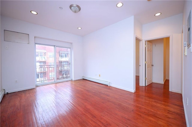 unfurnished room with dark hardwood / wood-style flooring and a baseboard heating unit