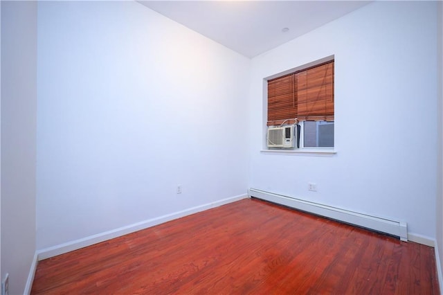 empty room featuring cooling unit, wood-type flooring, and a baseboard radiator