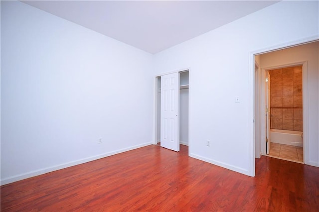 unfurnished bedroom featuring dark hardwood / wood-style flooring and a closet