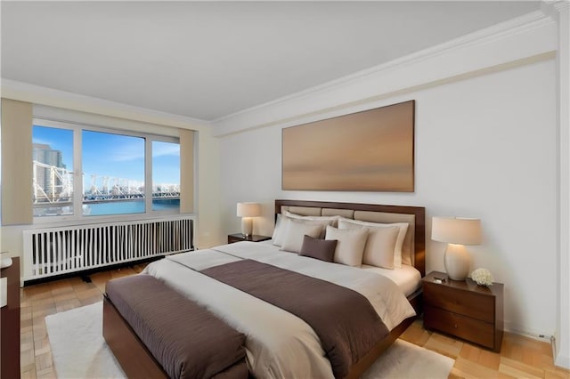 bedroom featuring radiator, a water view, crown molding, and wood finished floors