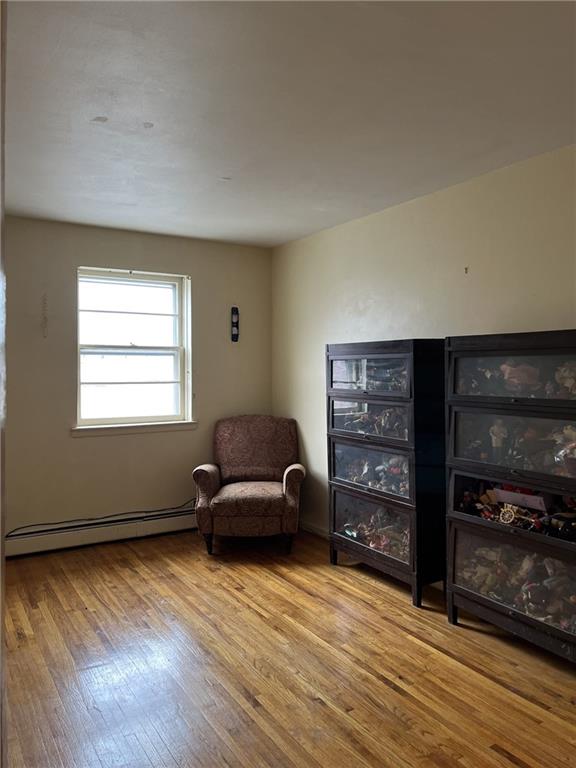 sitting room featuring baseboard heating and light hardwood / wood-style floors