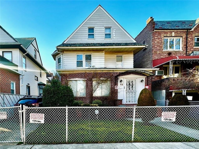 view of front of property featuring a fenced front yard, a gate, and brick siding