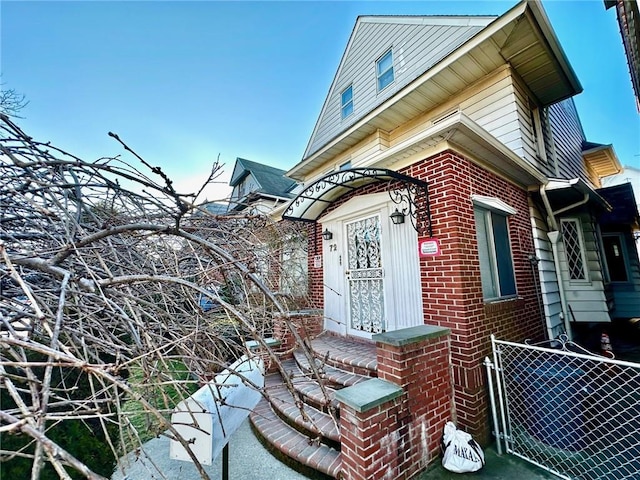 view of side of property with brick siding and fence