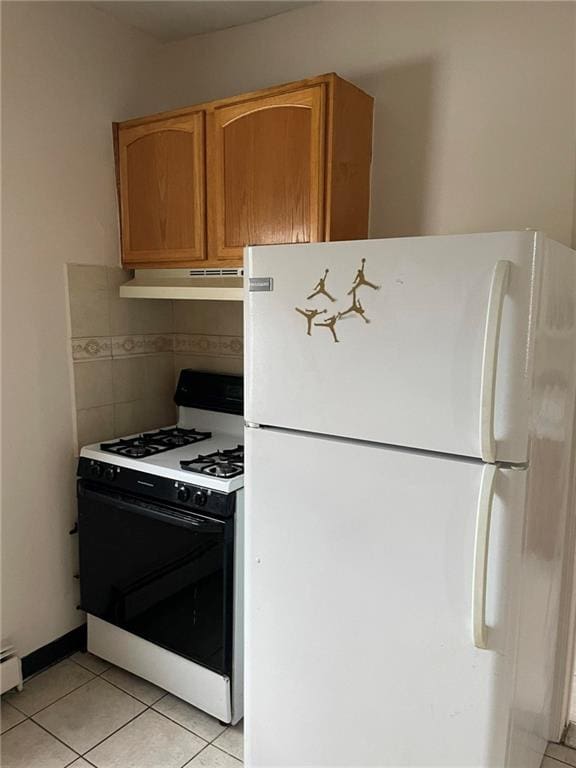 kitchen featuring white appliances, baseboard heating, light tile patterned floors, and tasteful backsplash