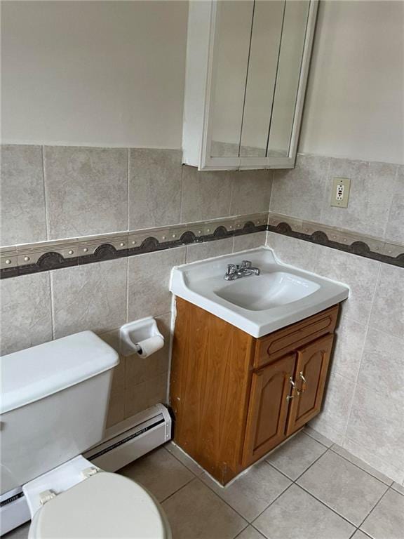 bathroom featuring tile patterned flooring, vanity, toilet, and baseboard heating