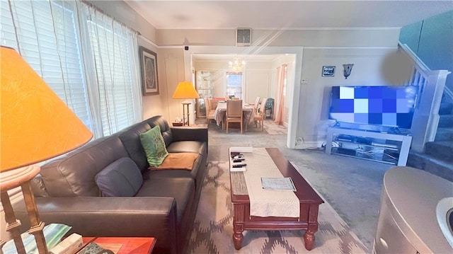 carpeted living room with plenty of natural light and a chandelier