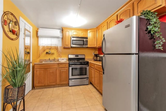 kitchen with sink, light tile patterned floors, and stainless steel appliances