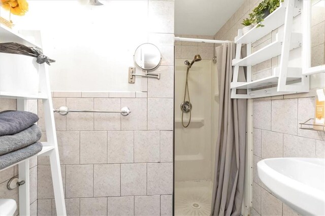 bathroom with tile walls and tiled shower