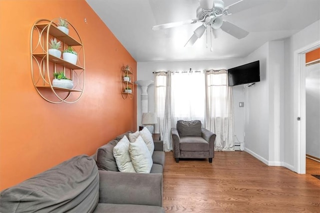 living room featuring ceiling fan, wood-type flooring, and a baseboard heating unit