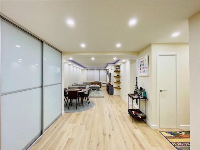 hallway with recessed lighting, light wood-style flooring, and baseboards