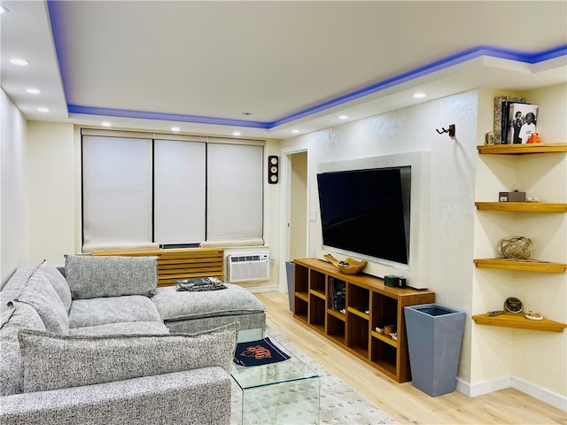 living area featuring baseboards, a wall unit AC, wood finished floors, and recessed lighting