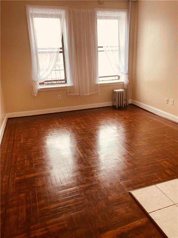 unfurnished room featuring radiator