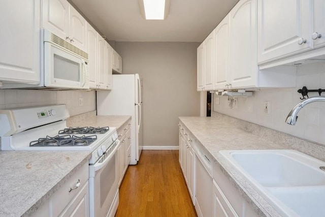 kitchen with sink, white cabinets, white appliances, and light hardwood / wood-style floors