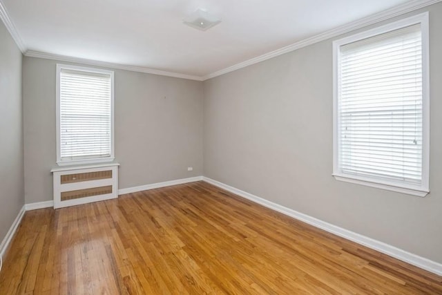 empty room featuring radiator, crown molding, and light hardwood / wood-style floors