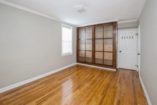 unfurnished bedroom with crown molding, light hardwood / wood-style floors, and a closet