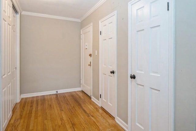 hallway featuring ornamental molding and light hardwood / wood-style floors