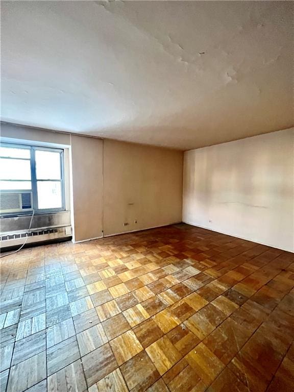 unfurnished room featuring cooling unit and a baseboard radiator