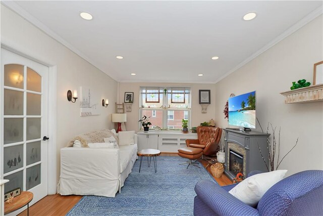 living room featuring ornamental molding, a fireplace, and hardwood / wood-style floors