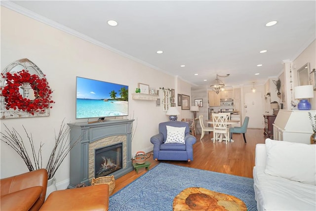 living room with hardwood / wood-style flooring, ornamental molding, and a stone fireplace