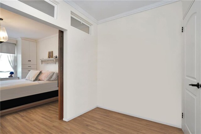 bedroom with crown molding and light hardwood / wood-style floors