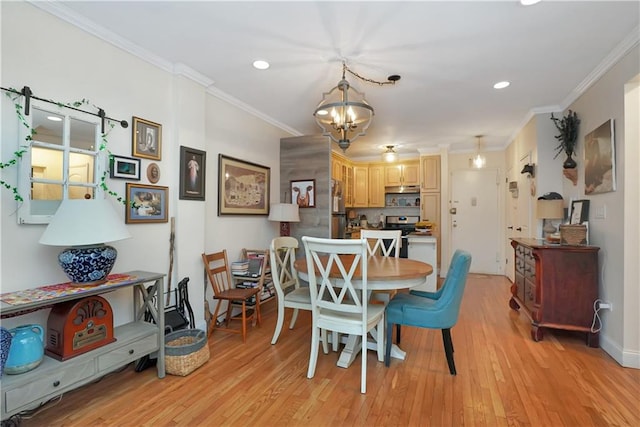 dining space featuring ornamental molding, a chandelier, and light wood-type flooring