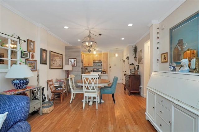 dining room featuring ornamental molding, a notable chandelier, and light hardwood / wood-style floors