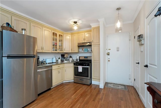 kitchen featuring pendant lighting, hardwood / wood-style flooring, stainless steel appliances, and crown molding