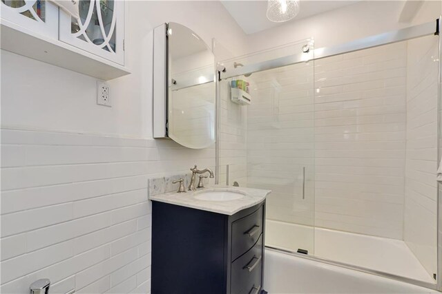 bathroom featuring vanity and shower / bath combination with glass door