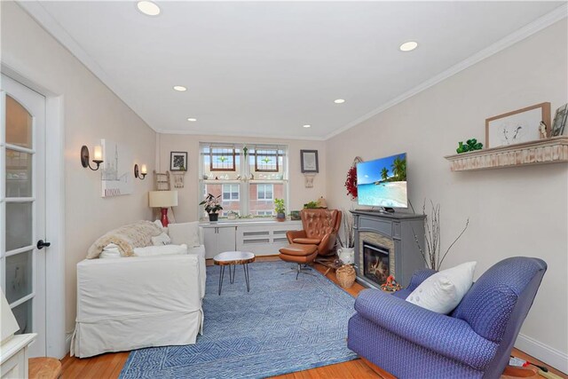 living room with ornamental molding and light hardwood / wood-style floors