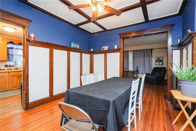 dining area with ceiling fan, coffered ceiling, and hardwood / wood-style floors