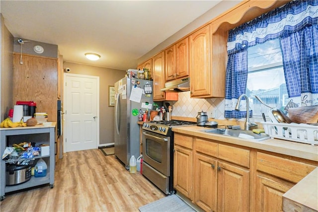 kitchen with appliances with stainless steel finishes, sink, light hardwood / wood-style flooring, and backsplash