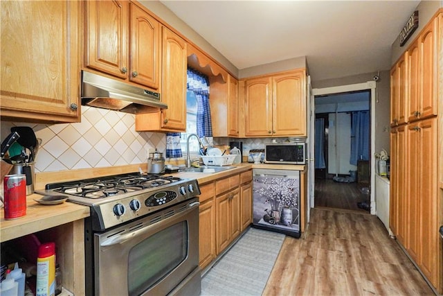 202 Watchogue Rd, Staten Island, NY 10314 - kitchen with stainless steel appliances, under cabinet range hood, a sink, decorative backsplash, and light wood-type flooring