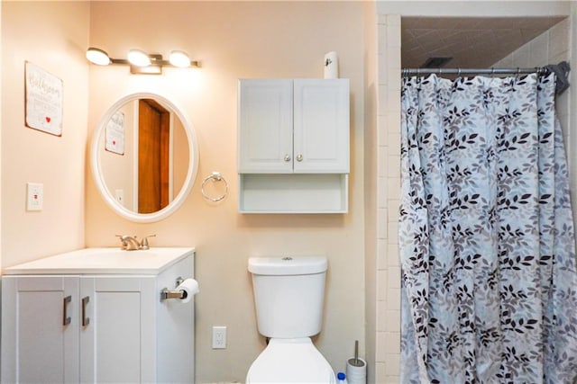 bathroom featuring vanity, curtained shower, and toilet