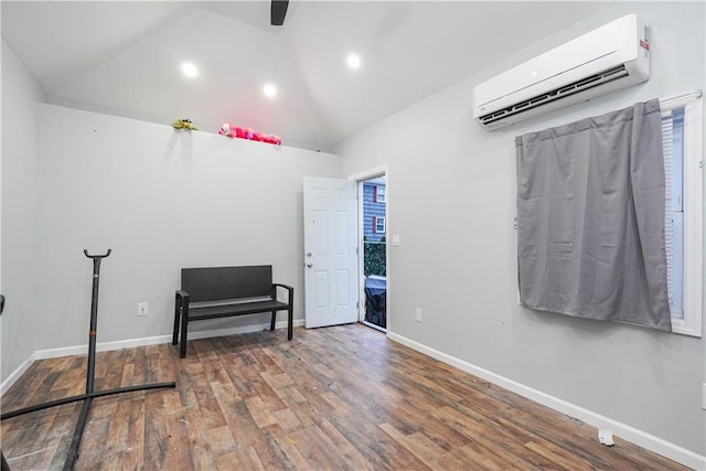 interior space with a wall mounted air conditioner, vaulted ceiling, and hardwood / wood-style floors