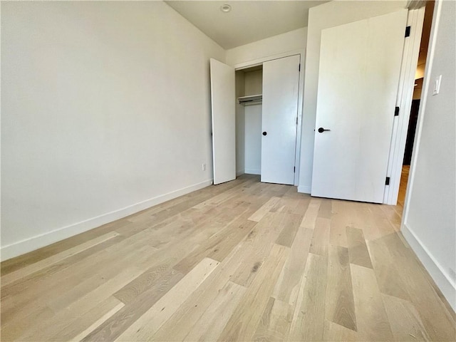 unfurnished bedroom with light hardwood / wood-style flooring and a closet