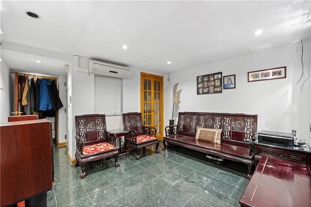 sitting room featuring a wall unit AC and french doors