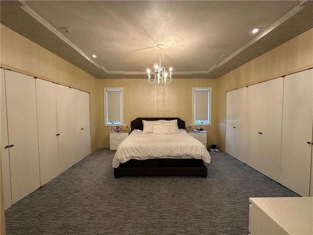 carpeted bedroom with a chandelier and a tray ceiling