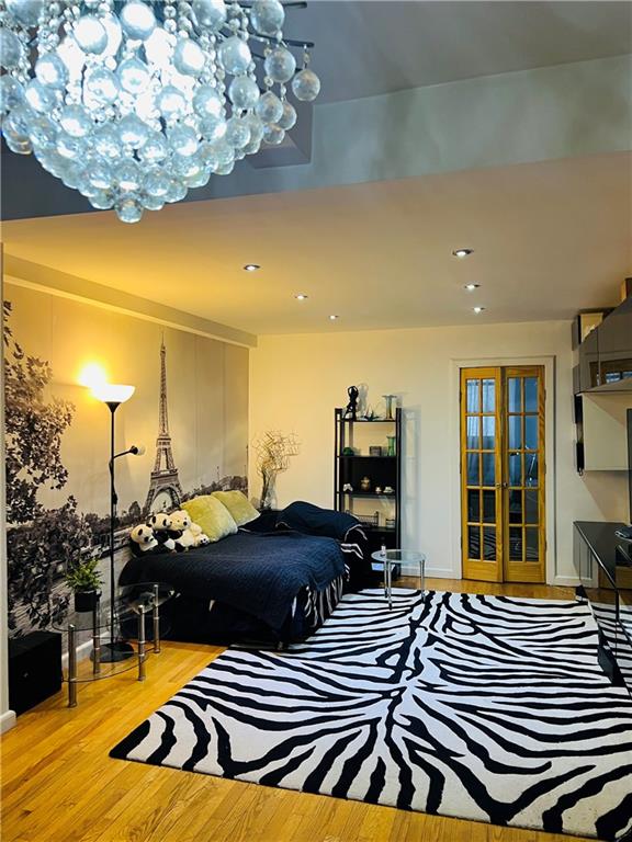 bedroom with french doors and light hardwood / wood-style floors