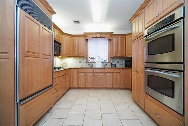 kitchen with light tile patterned flooring, ornamental molding, stainless steel appliances, and backsplash