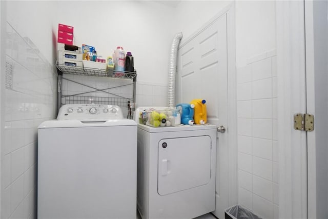 washroom with tile walls and washer and dryer