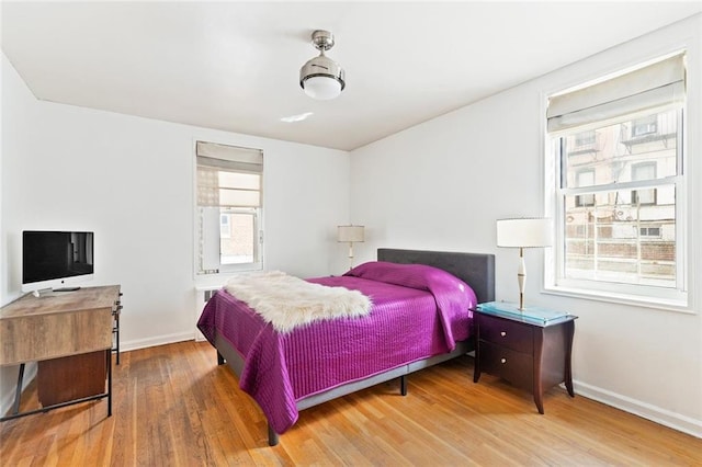 bedroom with multiple windows and wood-type flooring