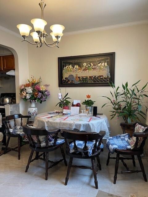 dining area with ornamental molding and a notable chandelier