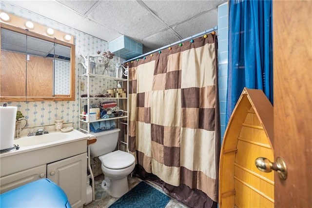 bathroom featuring a paneled ceiling, a shower with shower curtain, vanity, and toilet