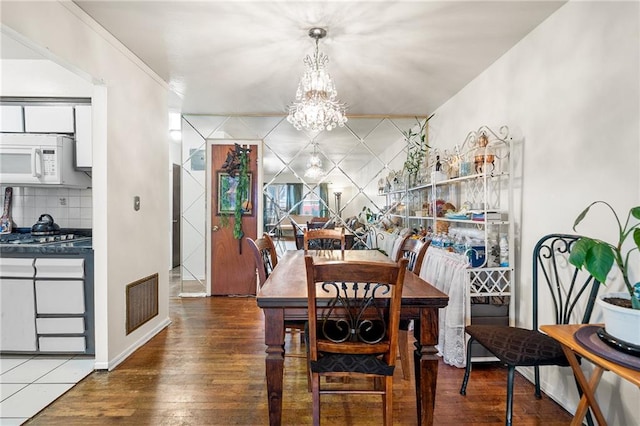 dining space with an inviting chandelier and dark wood-type flooring